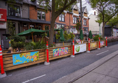 Cabbagetown Main St exhibit with a patio with fences and exhibited artworks.