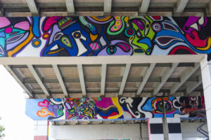 Close-up of a colourful mural under the Toronto Gardiner highway