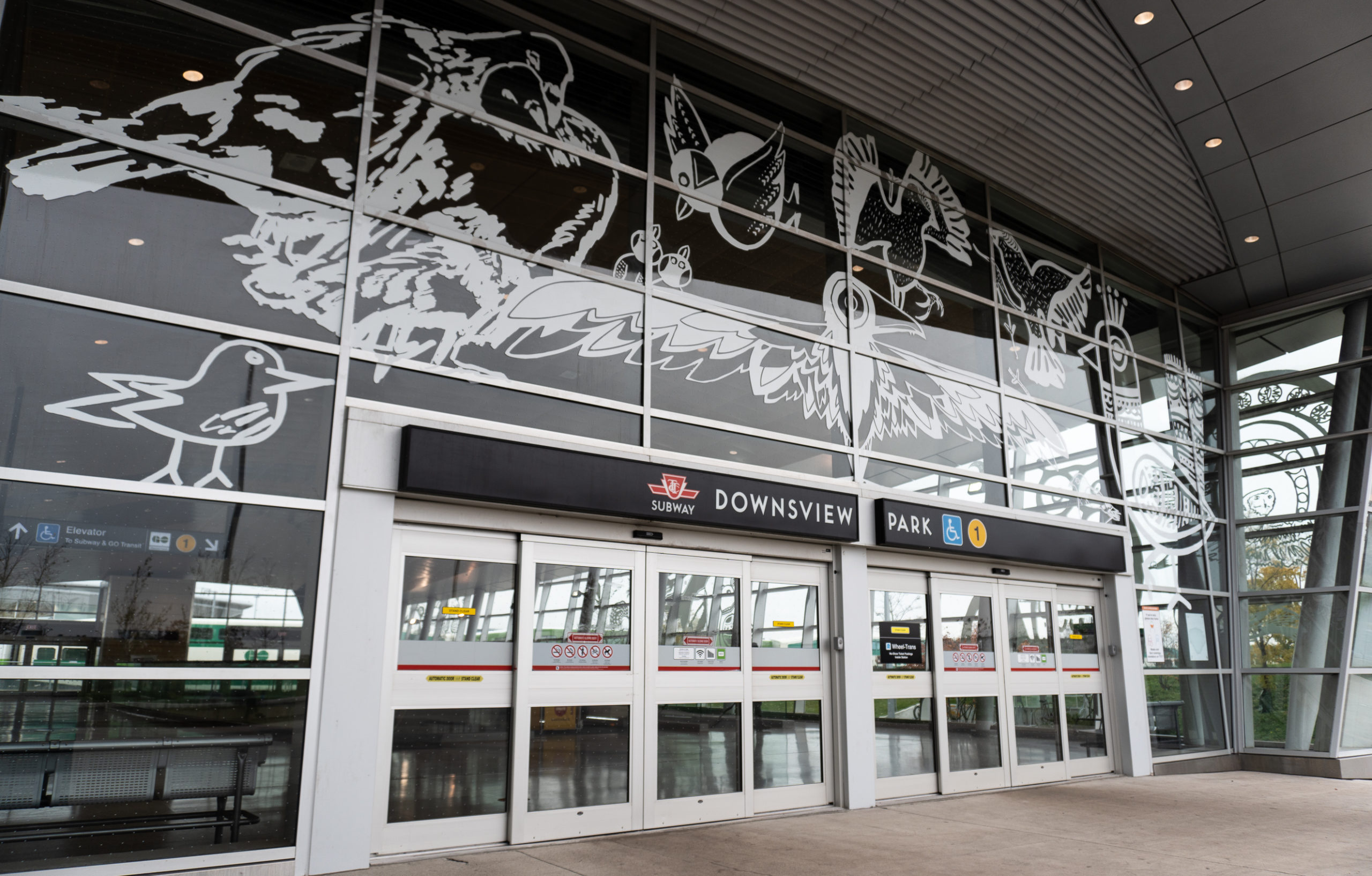 Photo of the entrance of Downsview Park Station decorated with a large-scale vinyl mural of different birds.