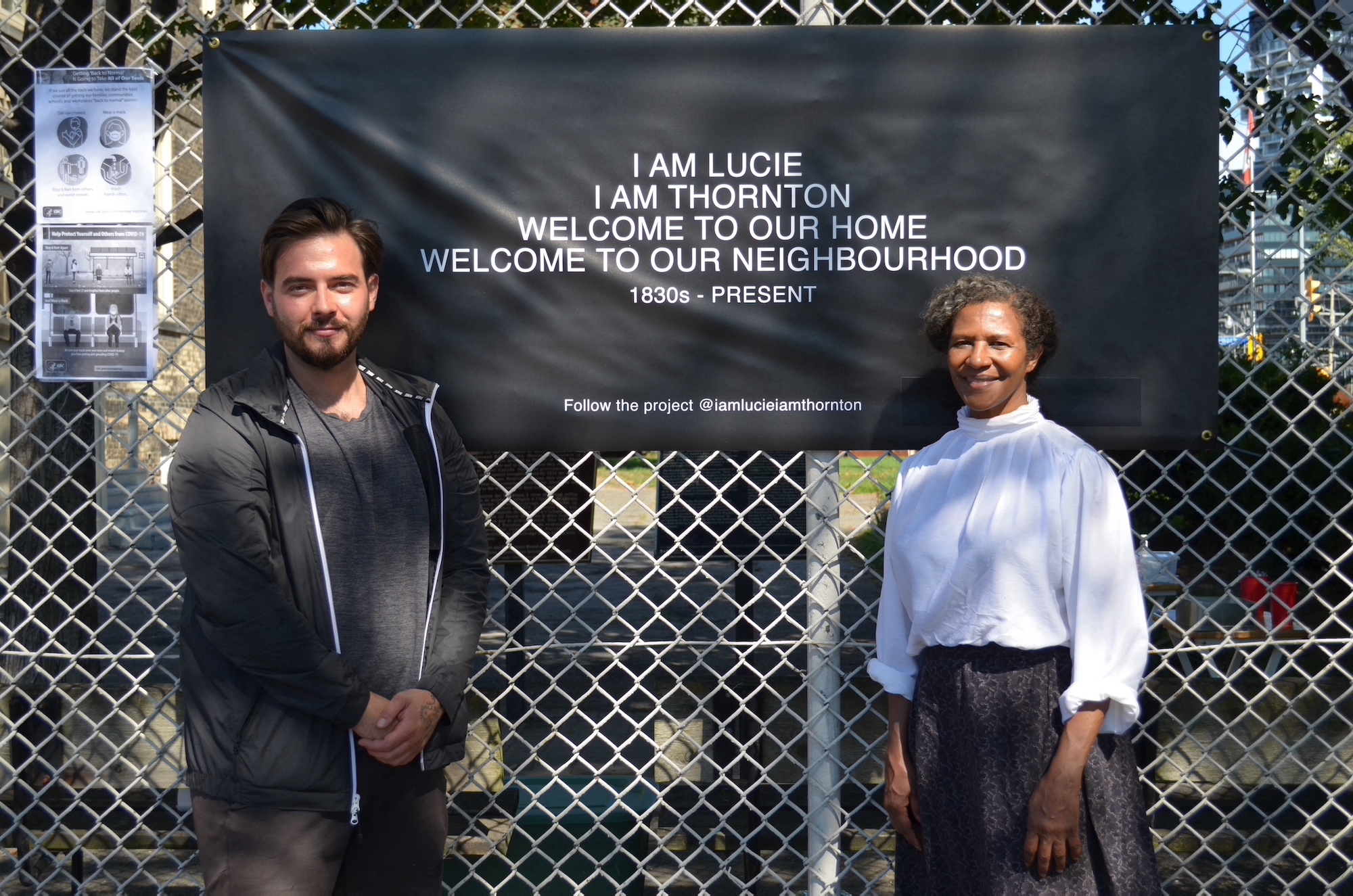 Photo of Stoyan Barakov of STEPS and artist Charmaine Lurch standing in front a black and white banner for Lurch's art installation.