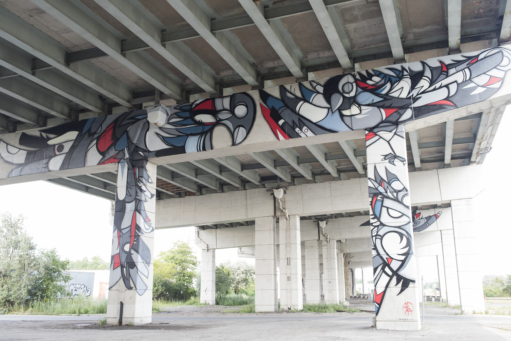 A large mural under Toronto's Gardiner highway by Fatspatrol. The mural showcases bird imagery