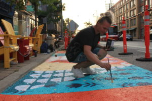 Image of a person painting on the ground.