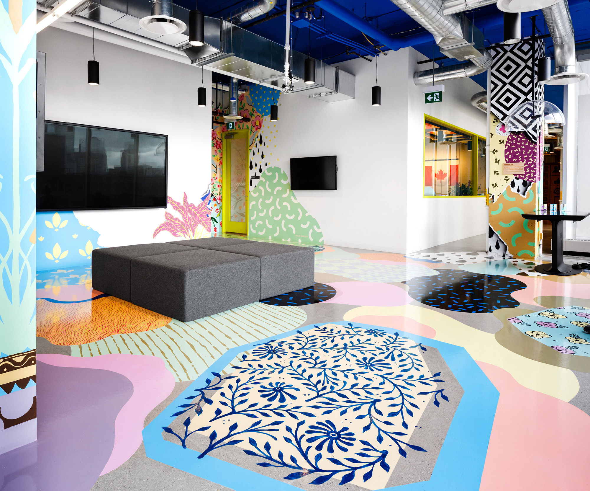 Indoor mural on walls and floor showing abstract shapes, colours and flowers