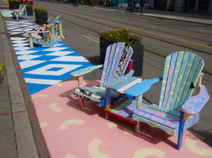 Muskoka chairs and pavement painted with abstract colourful patters