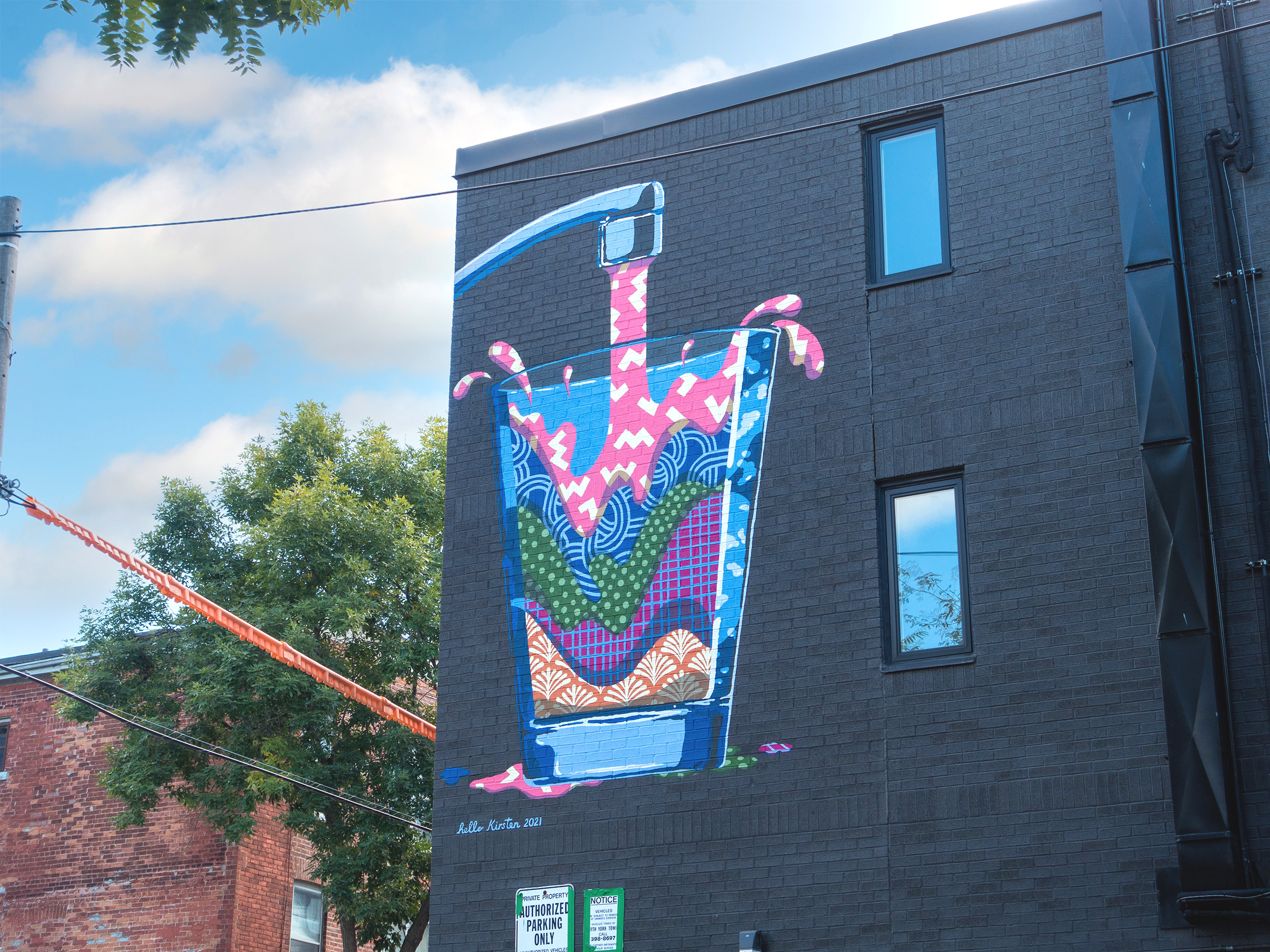 outdoor mural on the side of building showing a tap pouring colourful liquid into a glass