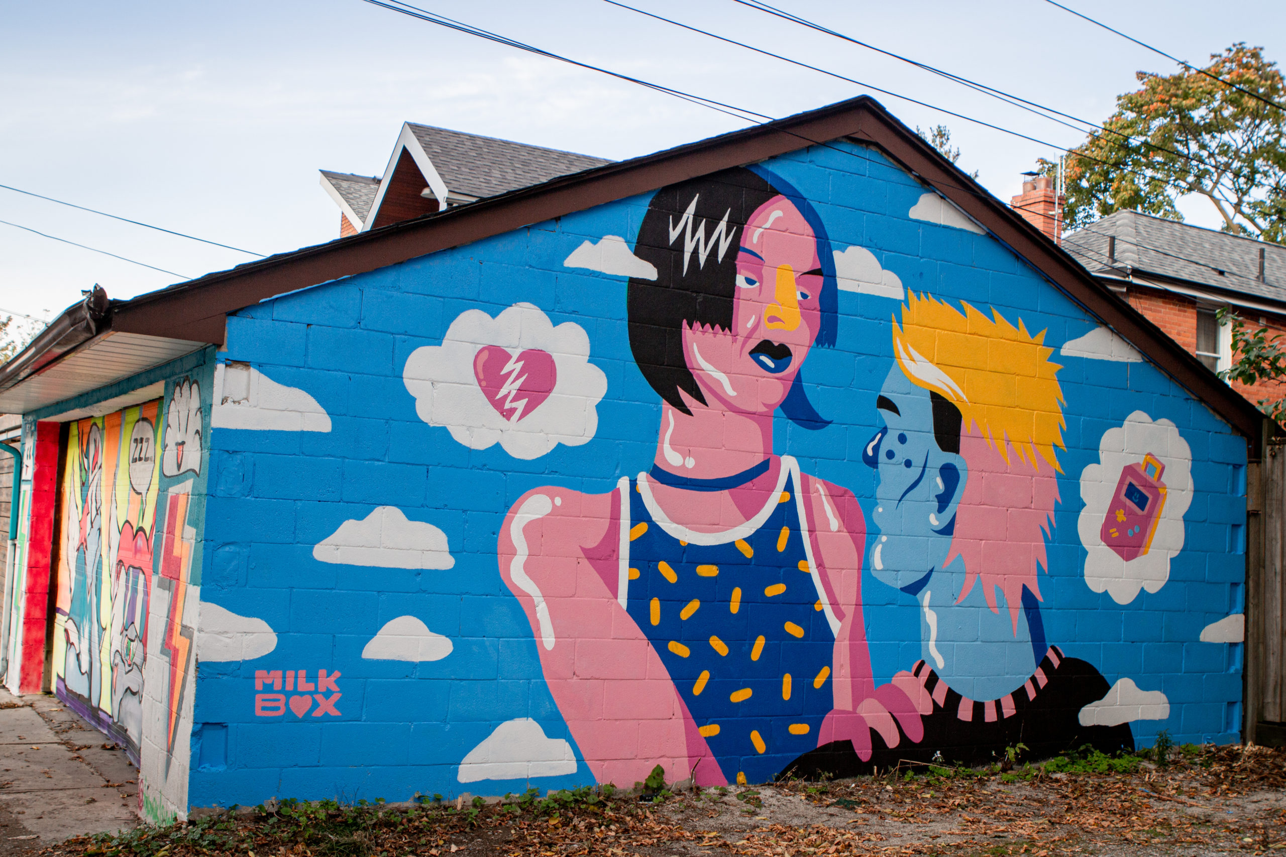 Mural on a side of a house deoicting a woman with blue background