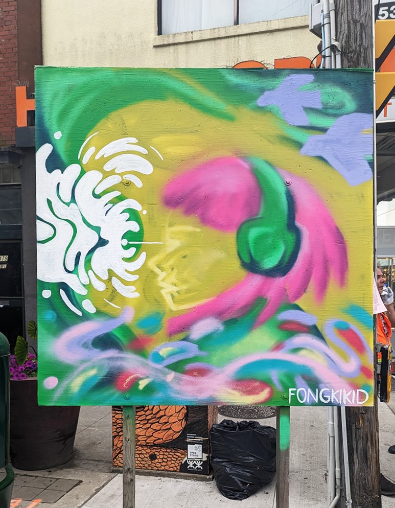 Photograph of a colourful artwork painted on canvas by Enna Kim. It features imagery of a figure in profile with green headphones and pink hair.