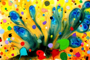 Abstract painting with a mix of blue and yellow in the background with colourful paint splatters layered on top