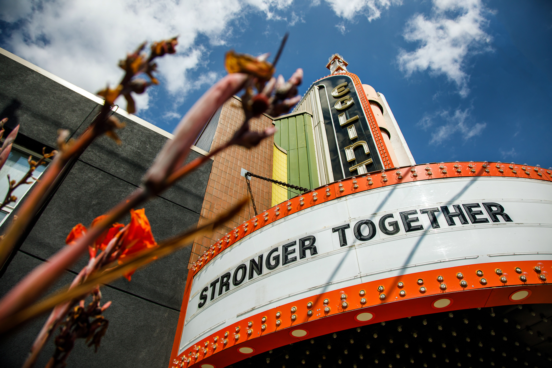 A closeup of a theatre with a marquee that reads "Stronger Together"