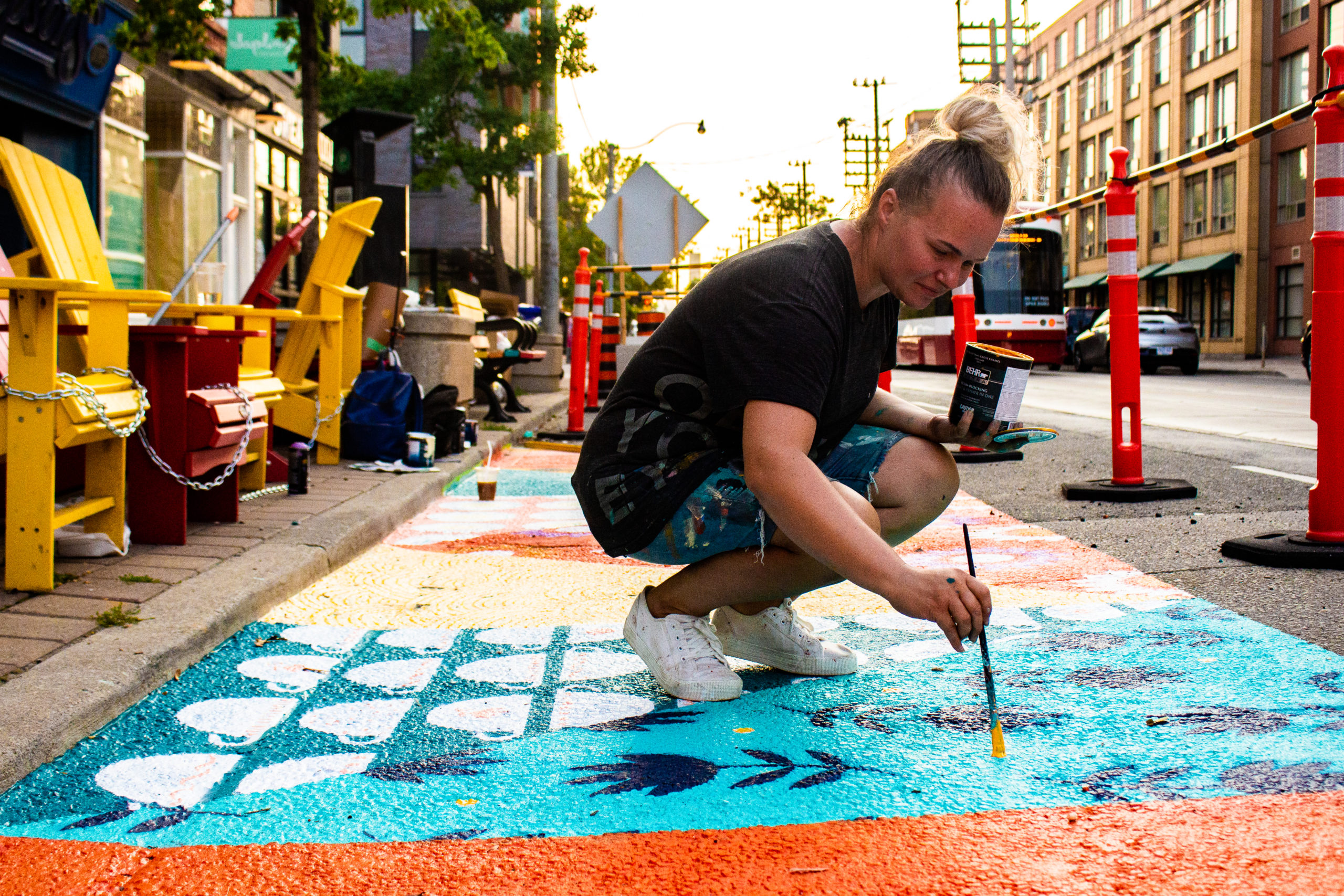 Gosia Komorski painting a ground mural in Toronto's Leslieville neighbourhood