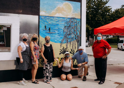 Jocelyn Kearns and local business owners posing in front of a newly painted mural in Belle River, Ontario