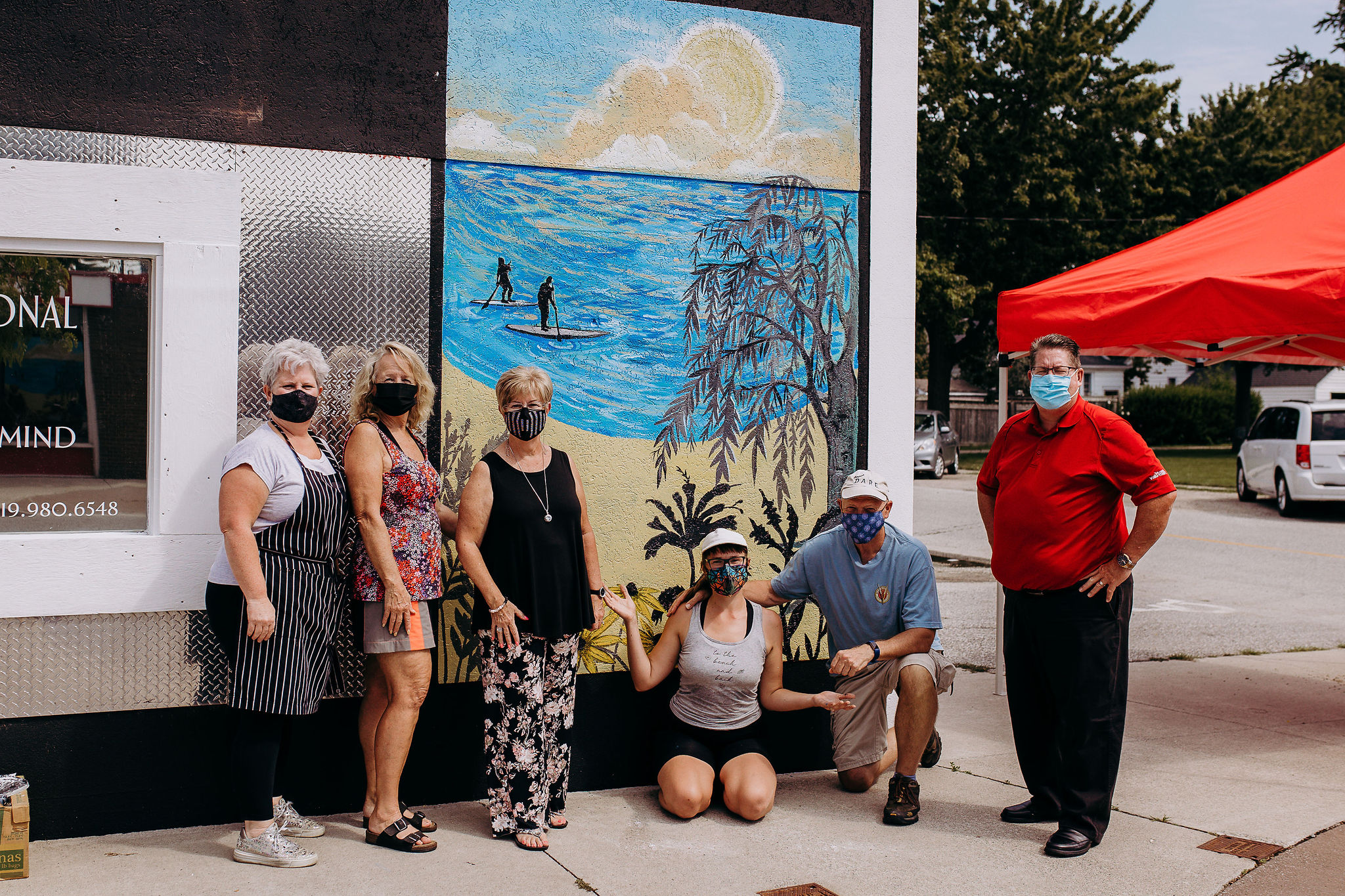 Jocelyn Kearns and local business owners posing in front of a newly painted mural in Belle River, Ontario