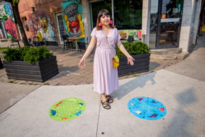 Marcia Diaz Agudelo standing in between her two designed sidewalk decals