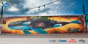 Large public art mural of a whale with different symbols of migration and immigration