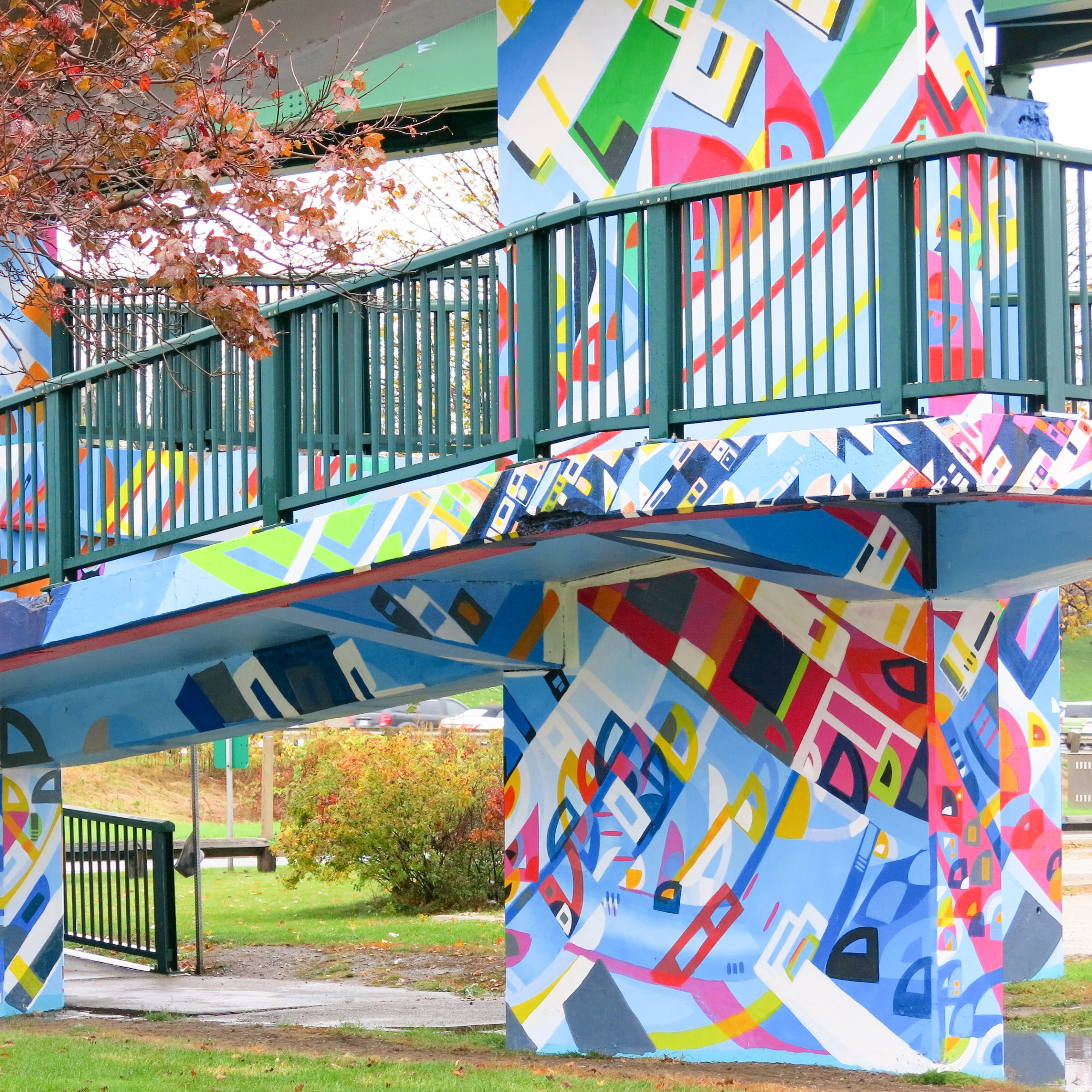 Photo of Sister Cities Mural by Justus Roe, with colours of blue, pink, green in a park