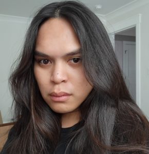 Headshot of Excel Garay who has long dark hair and looking sternly at the camera