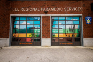 Landscape photo of Brampton Fire Station with red brick and a colour mural featuring wildlife and landscapes on the window.