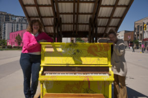 Artists Mar Lewis and Katie Green pose with the polinator piano in Downtown Barrie