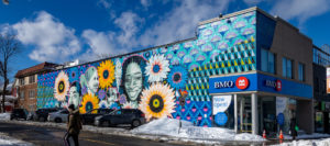 Outdoor mural on the side of BMO building depicting patterns, faces and flowers