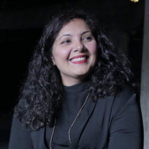 Headshot of Salima Punjani, a South Asian woman with medium skin, long curly hair.