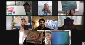 Photograph of a Zoom screen of a virtual art class. The 8 participants are holding up their art work in front of them.