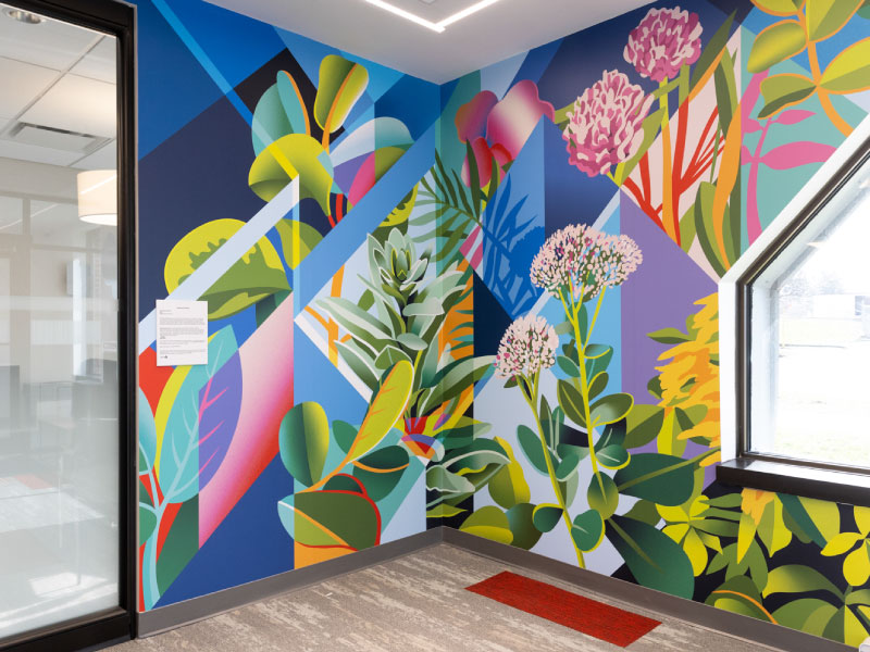 An interior digital vinyl mural by Stephanie Boutari as part of the BMO National Mural Series. It depicts colourful florals in geometric and organic styles.