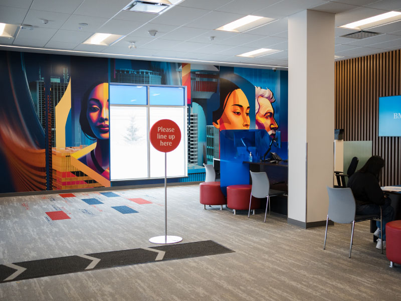 A mural of different portraits inside a bank as part of the BMO National Mural Series with STEPS Public Art by artist Kerzeka