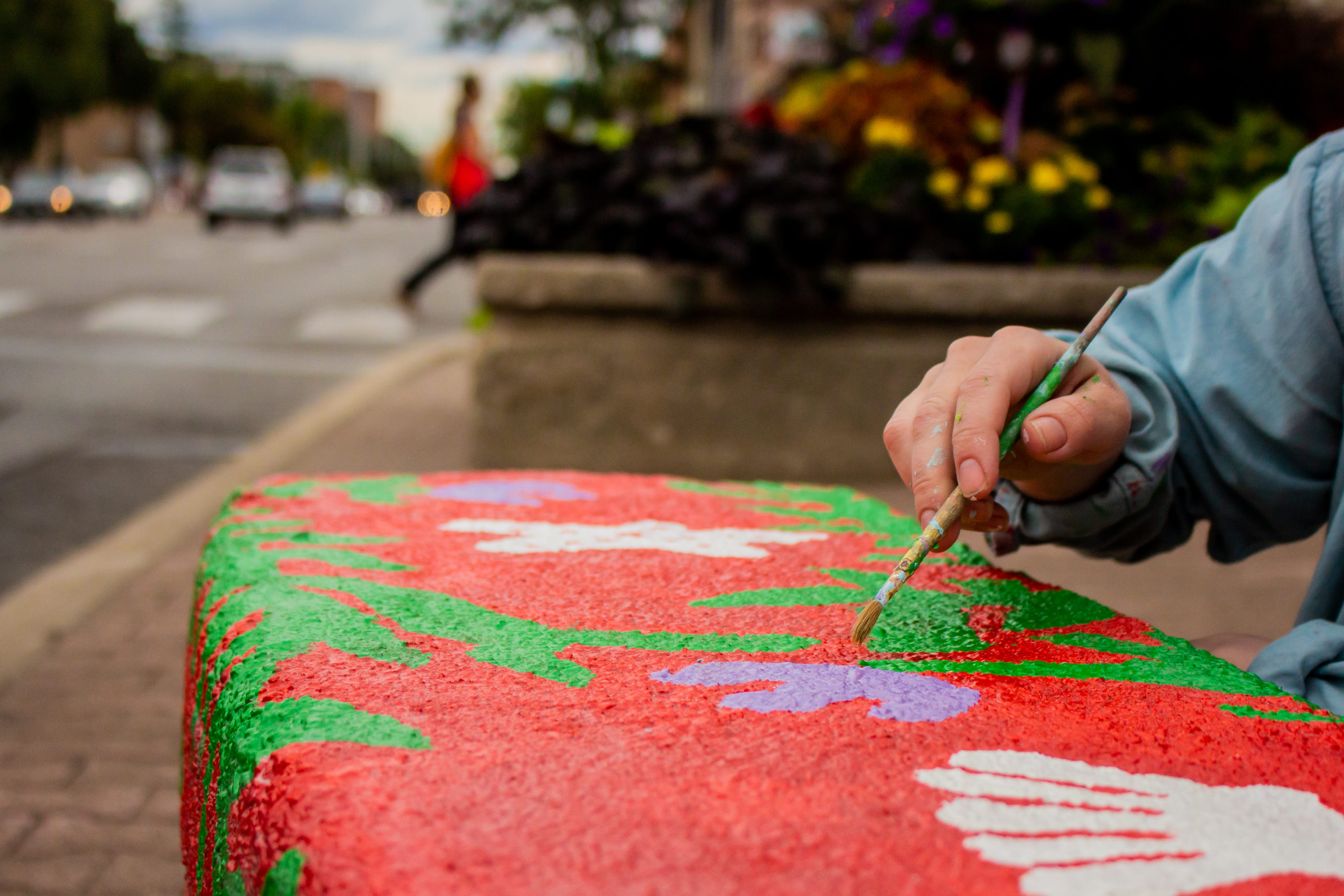 Artist erin mccluskey paints a bench for the port credit BIA I heART Main Street program