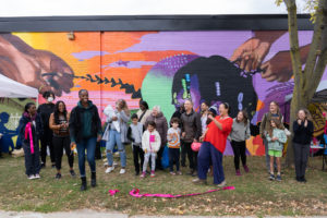 Community members at ribbon cutting ceremony to celebrate Our Crowns, a new public art mural in Toronto's Oakwood Village by mural artist Curtia Wright.