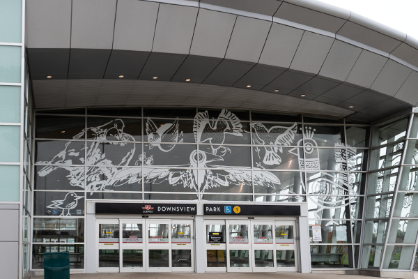 Large bird-safe white vinyl window decals at Downsview Park subway station in Toronto with imagery of birds