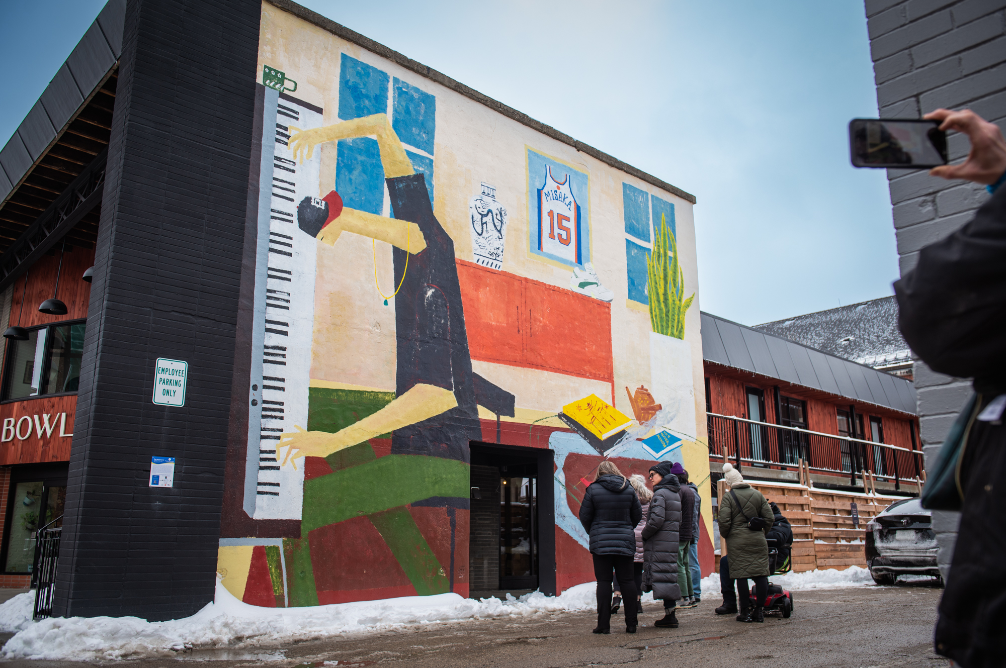 Members of the Downtown Stratford BIA gather under "The Perfectionist" mural by Kellen Hatanaka