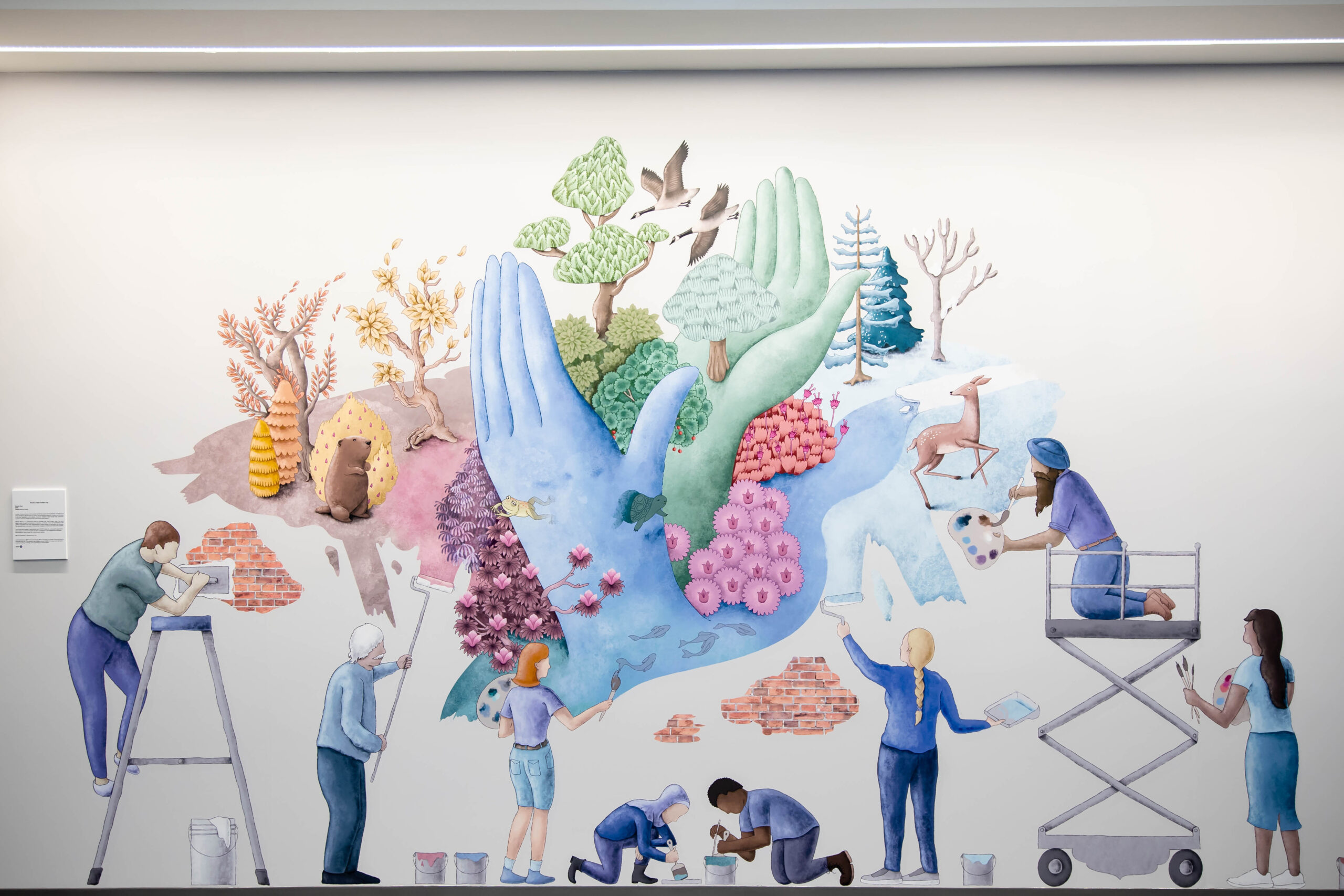 A completed mural by Keerat Kaur in pastel colours and illustrations of hands and people building and growing fruits.