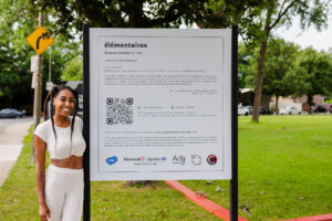 Ra'aanaa Yaminah stands with the Elemental exhibit in Montreal