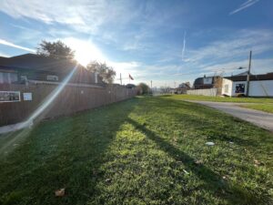 Westward facing view of the City of Hamilton pipeline trail that is long and grassy with surrounding residential homes