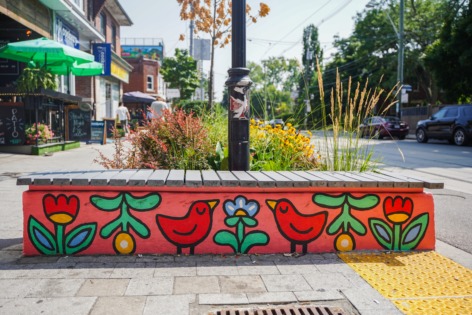 A painted bench by artist Natalie Very B with the support of STEPS Public Art and the Roncesvalles Village BIA