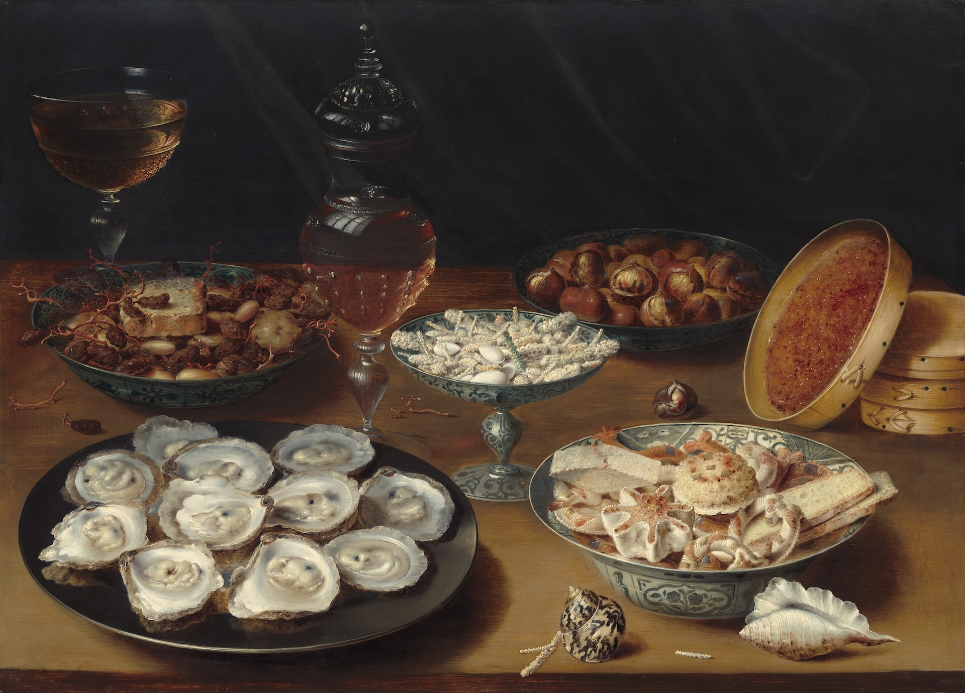 Still life painting of a table of food (oysters, fruit, wine) by Osias Beert the Elder