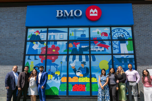 Bank staff and artist Sarah Taniwa in front of a new exterior mural as part of the BMO National Mural Series with STEPS Public Art