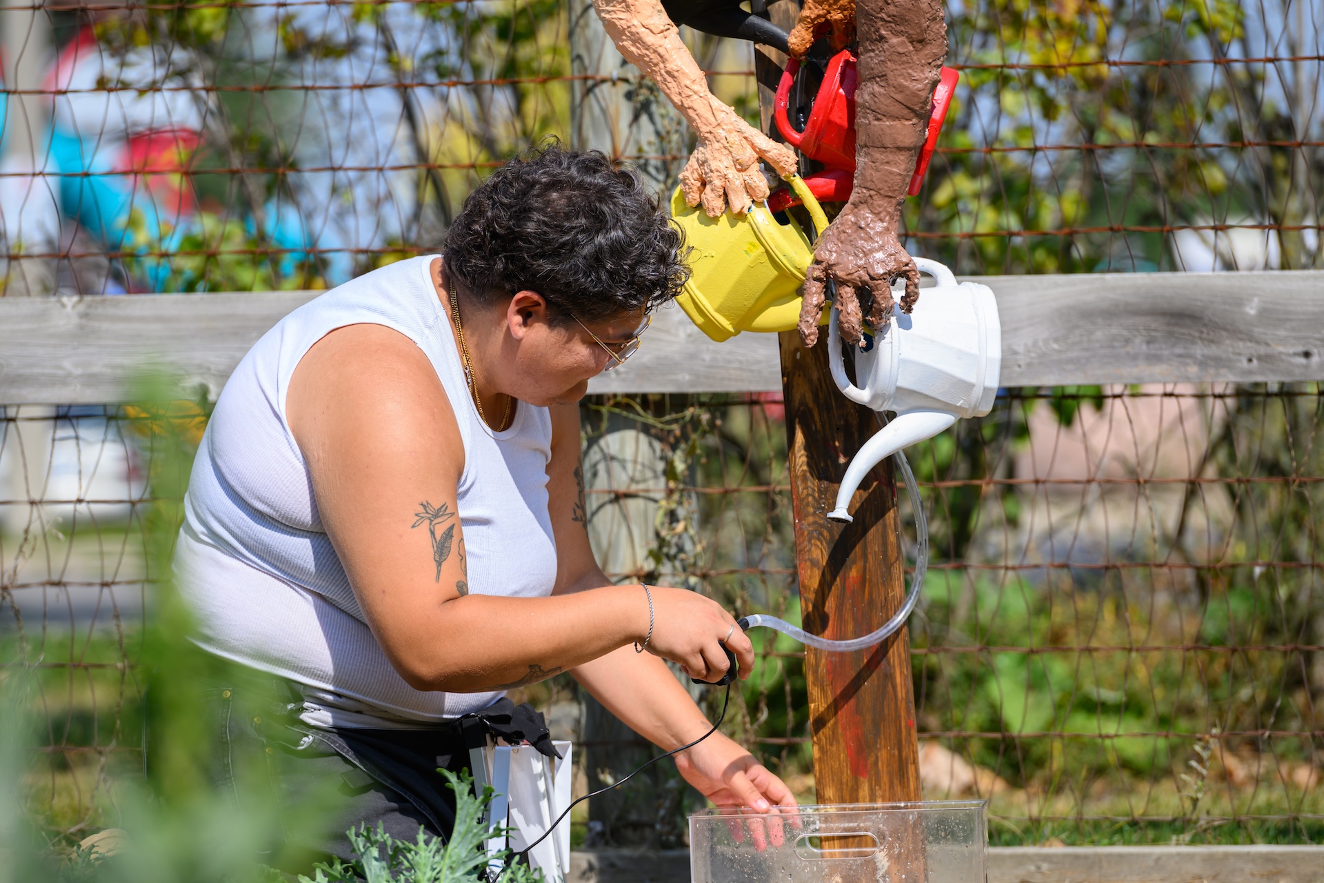 Artist Sar Wagman working on a sculptural installation in a garden as part of a sustainable project with STEPS Public Art